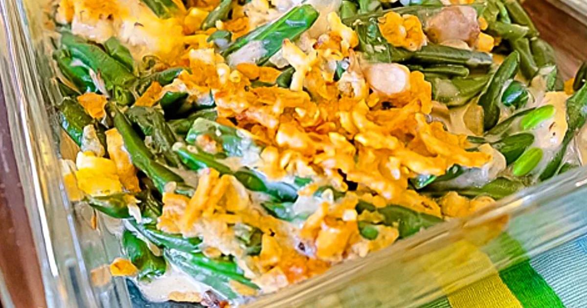 Green bean casserole in a creamy sauce with a crisp topping, baked golden and bubbling in a white dish