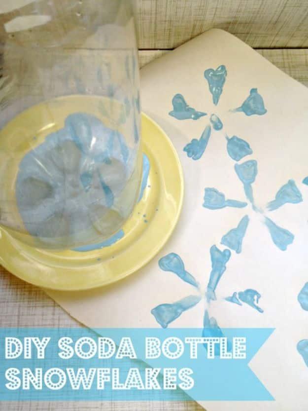 Base of a clear two liter bottle pressed into pale blue paint on a yellow plate beside a stamped snowflake print