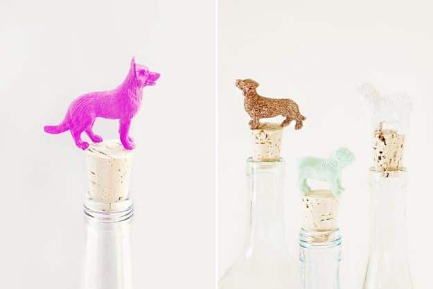 Two panels of bottle stoppers made from toy dogs glued to corks, one hot pink, others gold, mint and white glitter