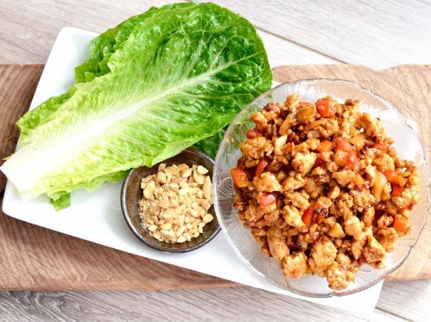 Asian chicken lettuce wraps with seasoned ground chicken, water chestnuts and green onion in lettuce
