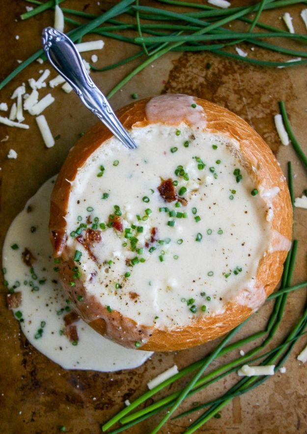 Spicy white cheddar beer cheese soup poured into a hollowed bread bowl and topped with bacon and chives