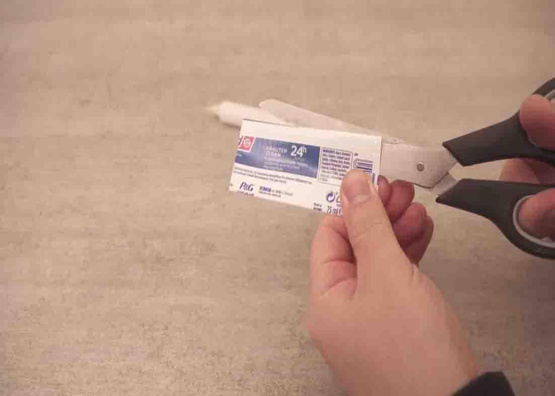 Cutting the empty toothpaste tube open