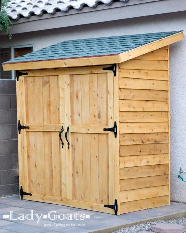 Small cedar shed, a cedar fence picket shed with double doors and a green shingled lean-to roof against a block wall