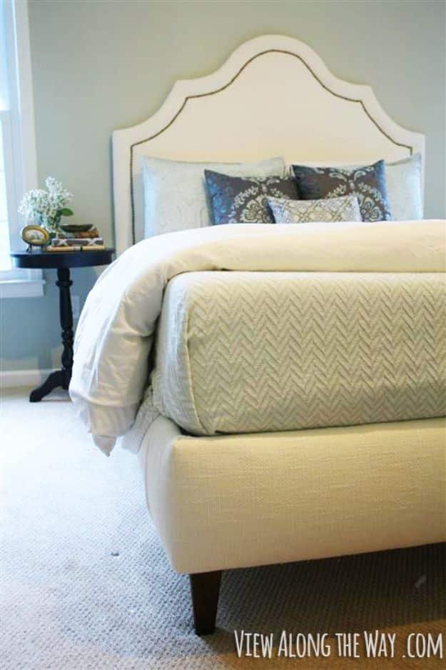 Upholstered DIY bed frame with a curved cream headboard, nailhead trim and an upholstered platform base