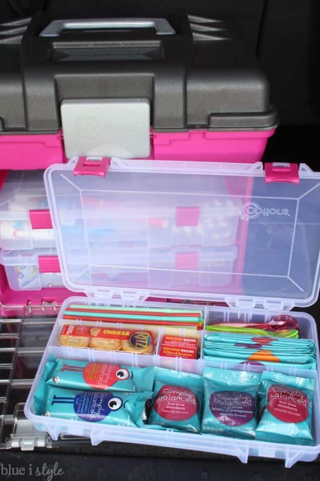Organized car kit, a pink and clear craft storage case open with teal trays of first aid supplies and snacks