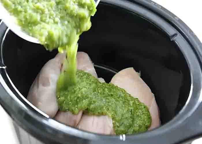 Adding the chicken and the salsa verde in the crockpot