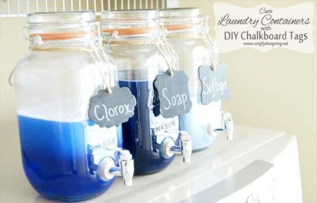 Three glass drink dispensers of laundry detergent, bleach and softener with painted chalkboard tags tied on twine