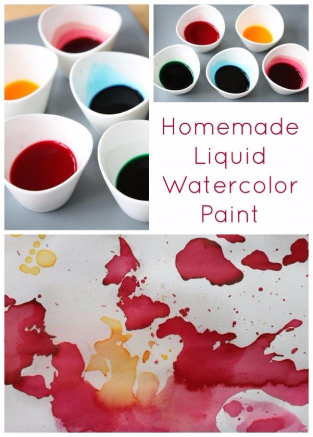 Homemade liquid watercolor paint, small white bowls of red orange and teal dye beside a bright watercolor wash on paper