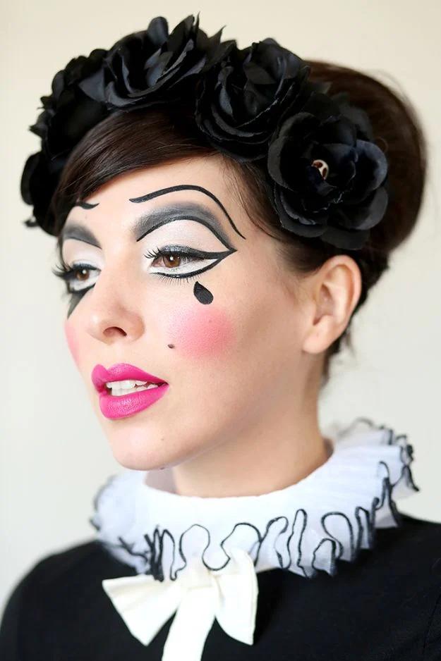 Harlequin doll Halloween makeup with white face paint, black diamond eye shapes, pink cheeks and curled hair
