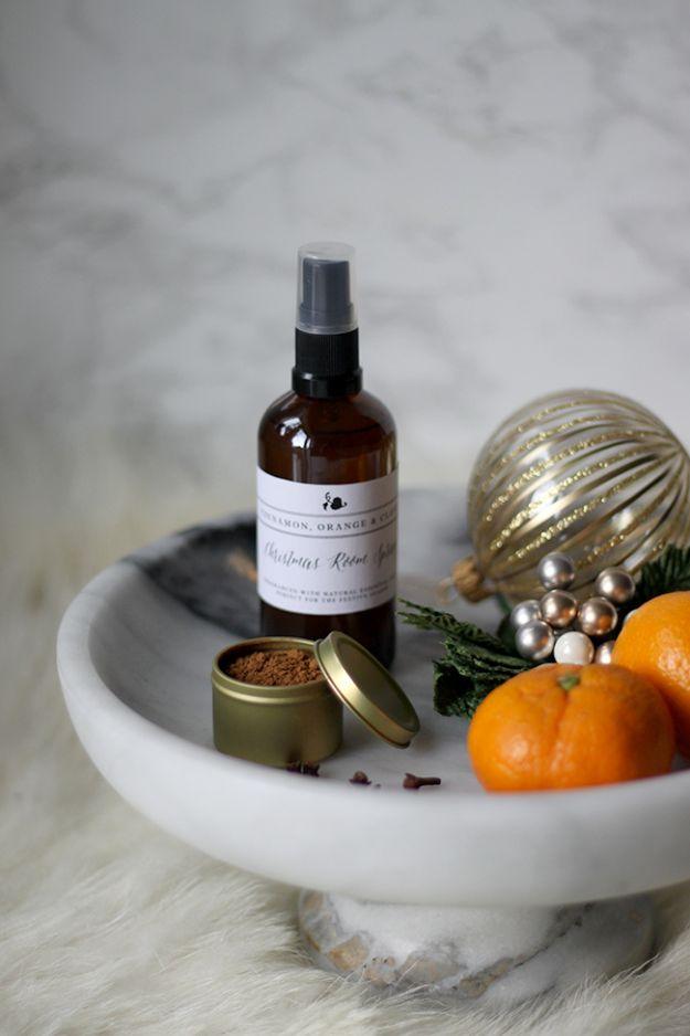 Amber glass room spray bottle on a marble stand with clementines, a gold ornament and a dish of ground spice