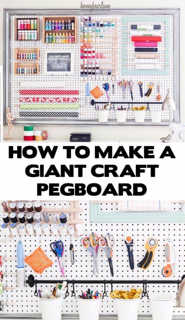 Giant framed pegboard holding paint, thread spools, washi, rulers, scissors and rotary cutters, buckets along a lower rail