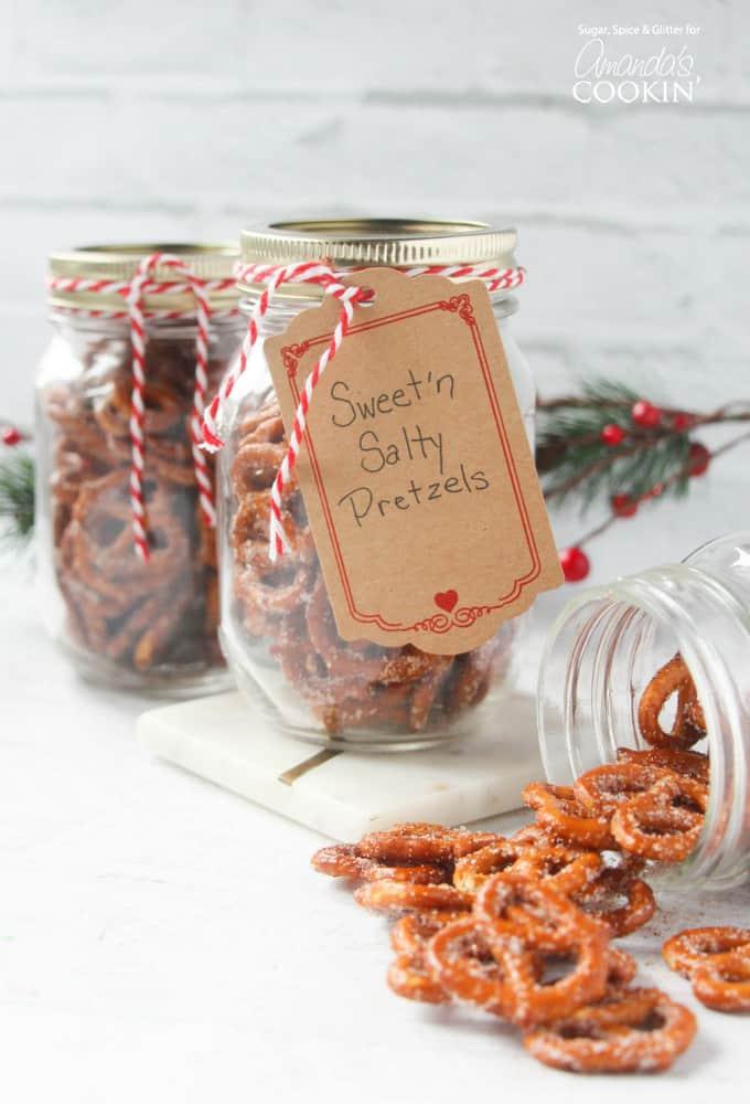 Tall glass jar filled with sweet and salty coated pretzels, tied with ribbon and a small handwritten gift label