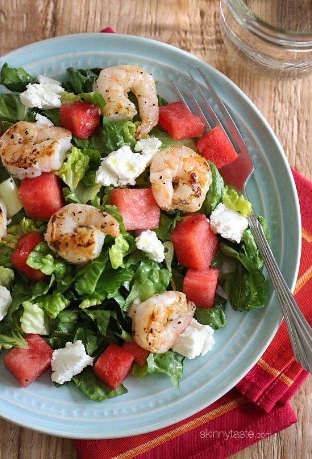 Grilled shrimp and watermelon chopped salad with romaine, diced watermelon and goat cheese on a pale blue plate
