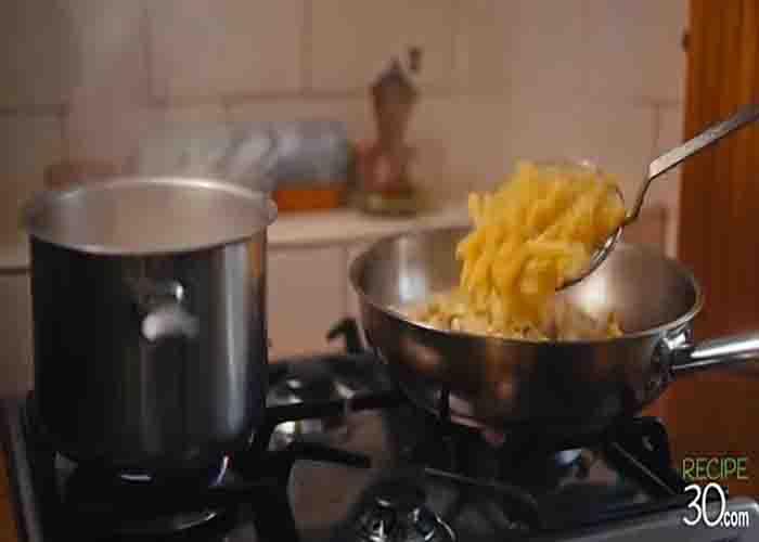 Mixing the penne pasta with the cauliflower and the sauce