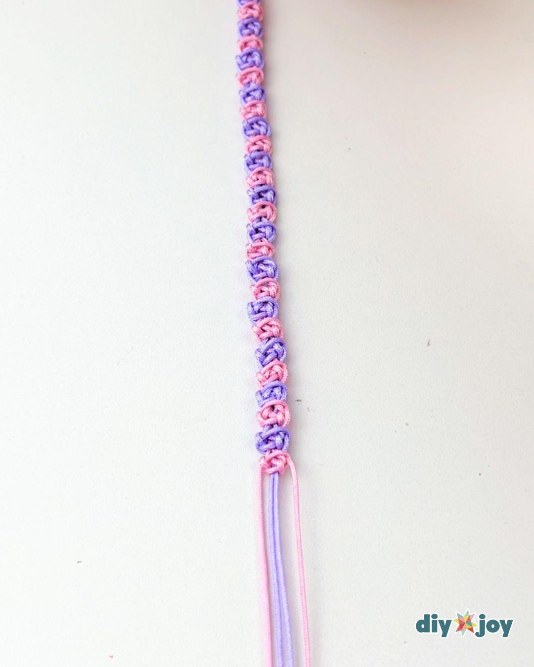 A simple macrame bracelet pattern shown in close detail, with even square knots running the length of the band