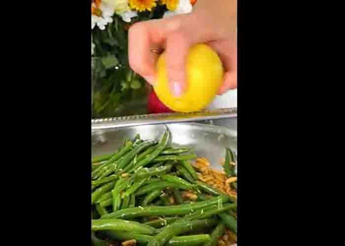 Garnishing the green beans almondine with some lemon zest