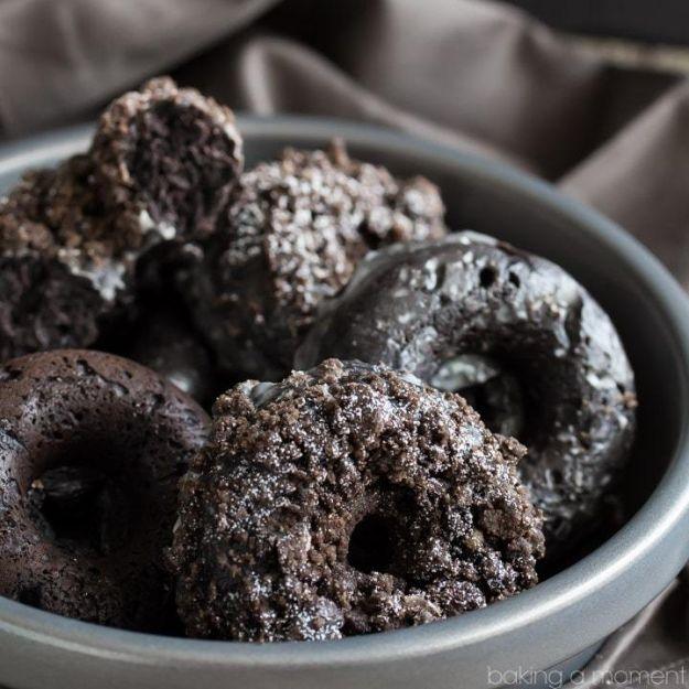 Baked chocolate crumb donuts piled into a grey metal bowl, dark cocoa crumb topping catching the light