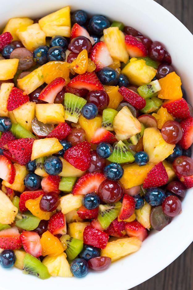 Rainbow fruit salad of strawberries, pineapple, blueberries, red grapes and kiwi in a white serving bowl