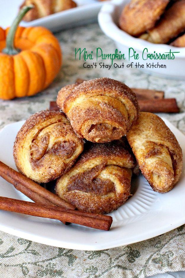 Plate of mini pumpkin pie croissants rolled in cinnamon sugar with cinnamon sticks and a small pumpkin
