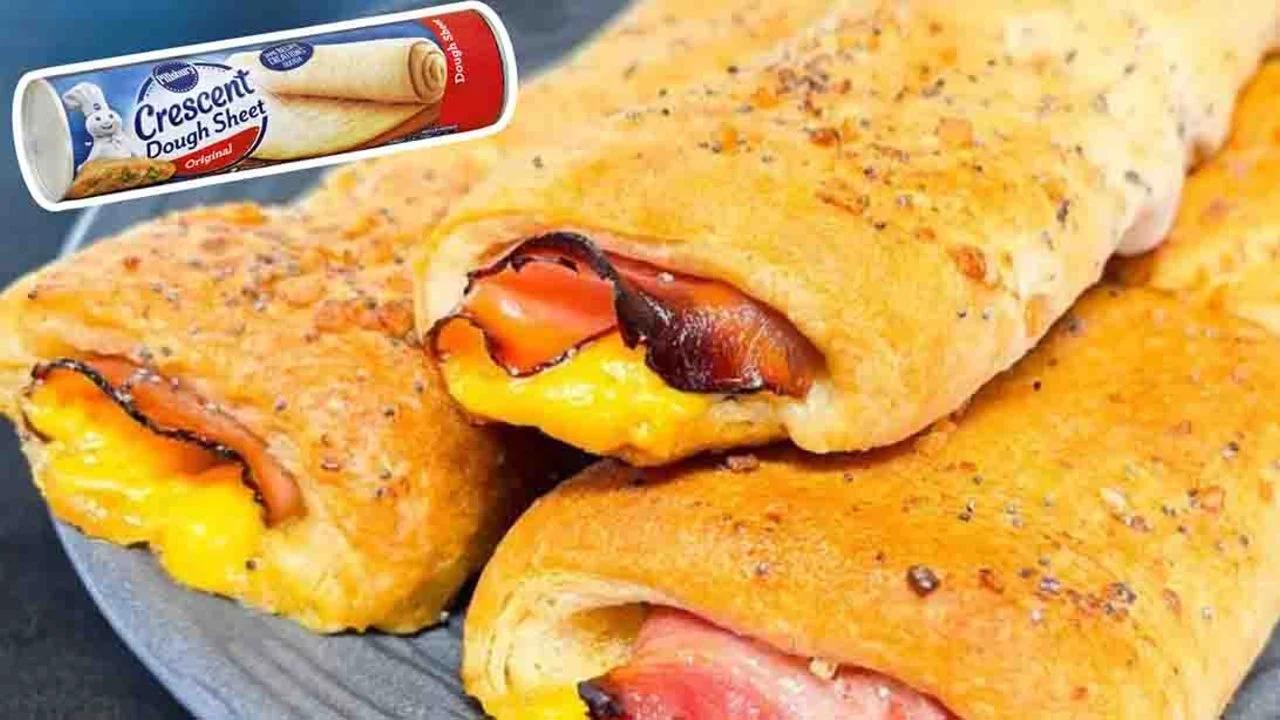 Ham and cheese crescent sticks brushed with poppy seed butter glaze, baked golden on a parchment sheet pan