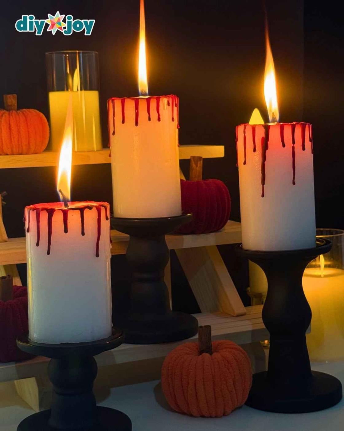 Bloody candles arranged with other creepy Halloween decorations and dripping red wax for a spooky gothic display.