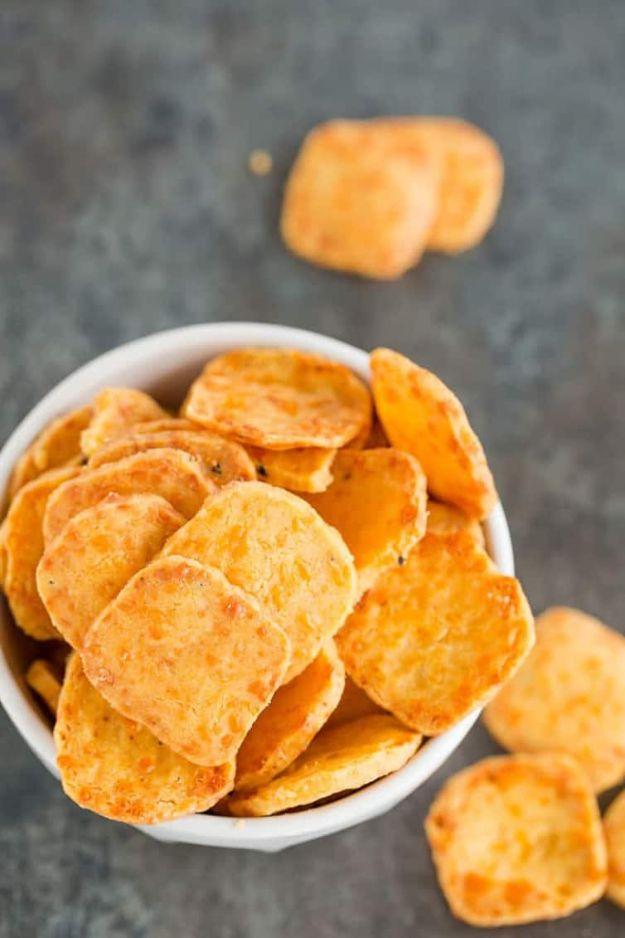 Spicy southern cheese crackers, small square orange cheddar crackers piled in a white bowl on a board