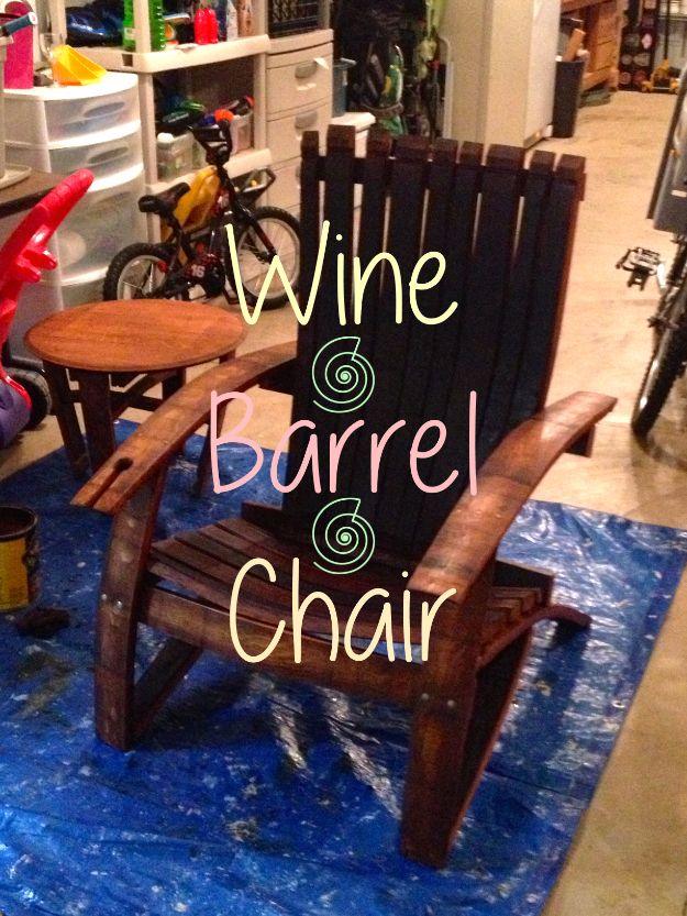 Repurposed wine barrel chair built from curved oak staves and stained dark red, standing on a blue tarp in a garage