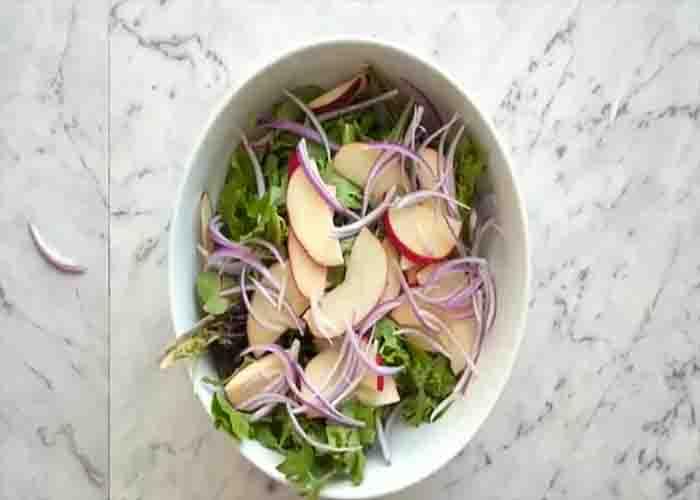 Assembling the apple salad with walnuts and cranberries
