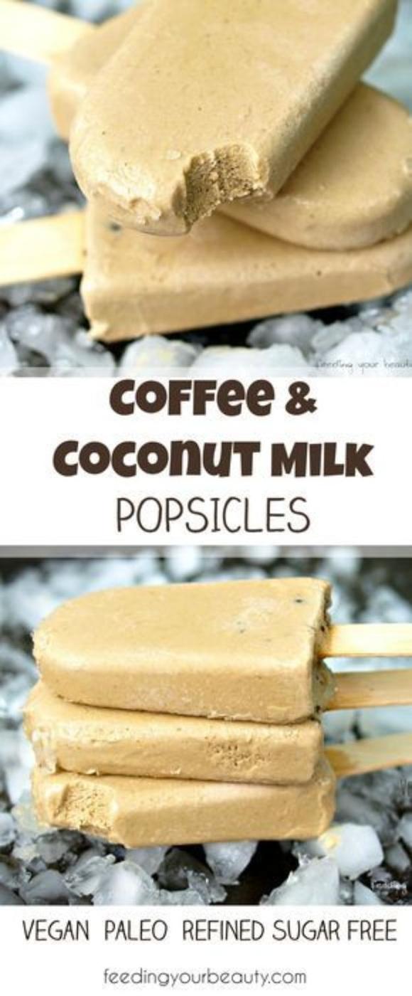 Pale tan coffee and coconut milk popsicles stacked on a bed of crushed ice with wooden sticks showing