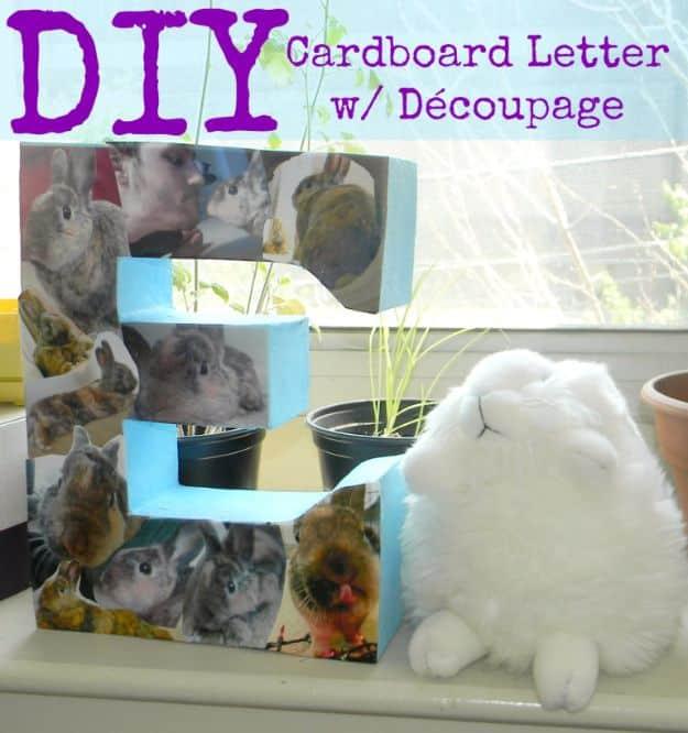 Cardboard craft letter E decoupaged with rabbit photographs standing on a windowsill beside a white toy rabbit
