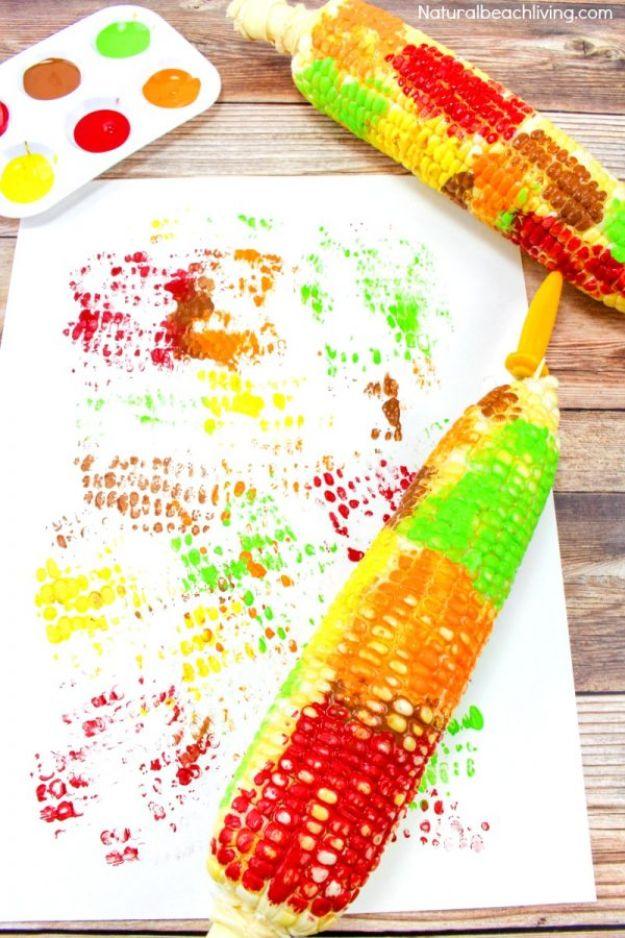 Fall craft for kids, corn cobs painted in fall colors beside a rolled corn print and a paint palette