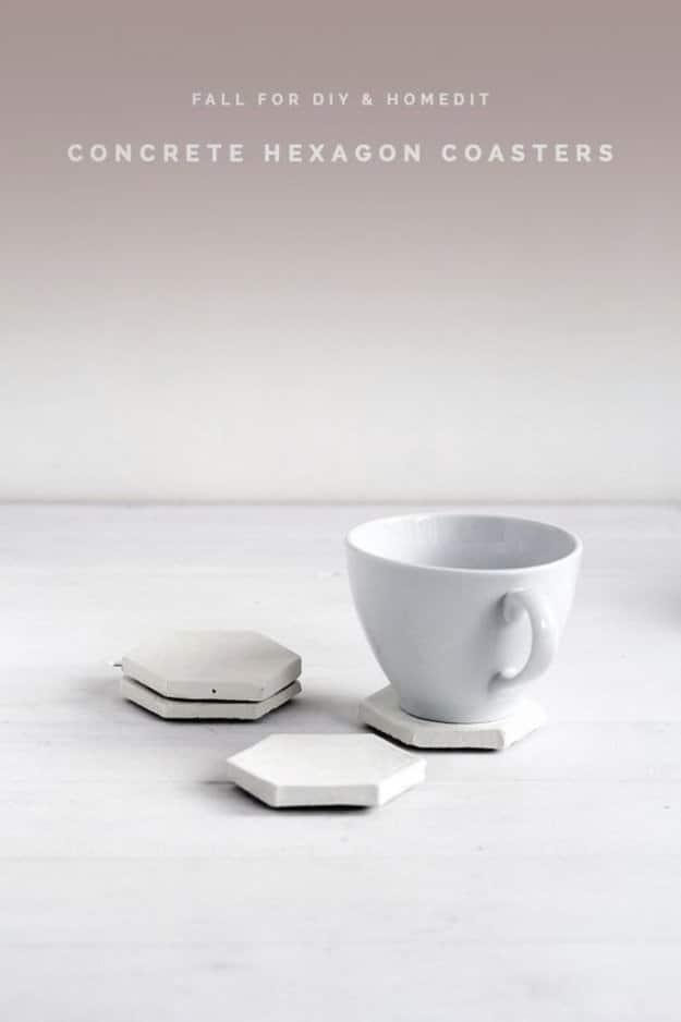 Concrete hexagon coasters, three small pale cast cement hexagons beside a white teacup on a pale wooden table