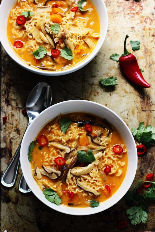 Spicy Thai style pumpkin butternut ramen in two white bowls with noodles, mushrooms, squash and fresh cilantro