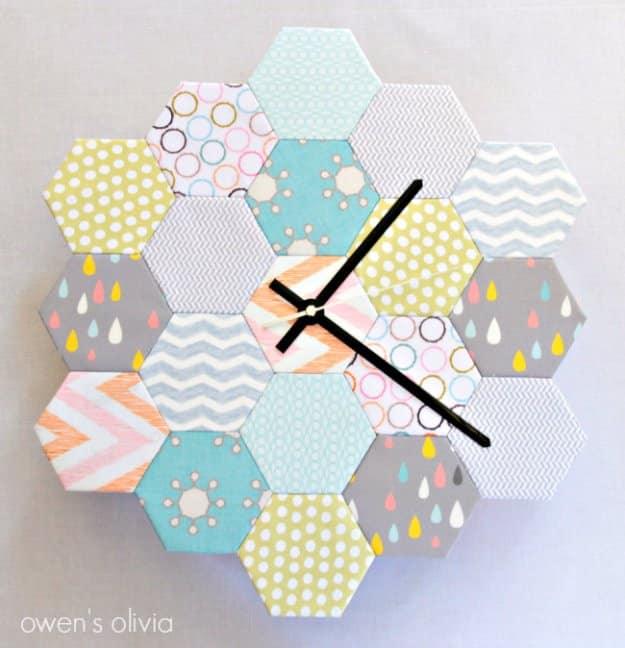 Round wall clock made of nineteen fabric covered hexagons in grey, mint and mustard prints with black hands, on a white wall