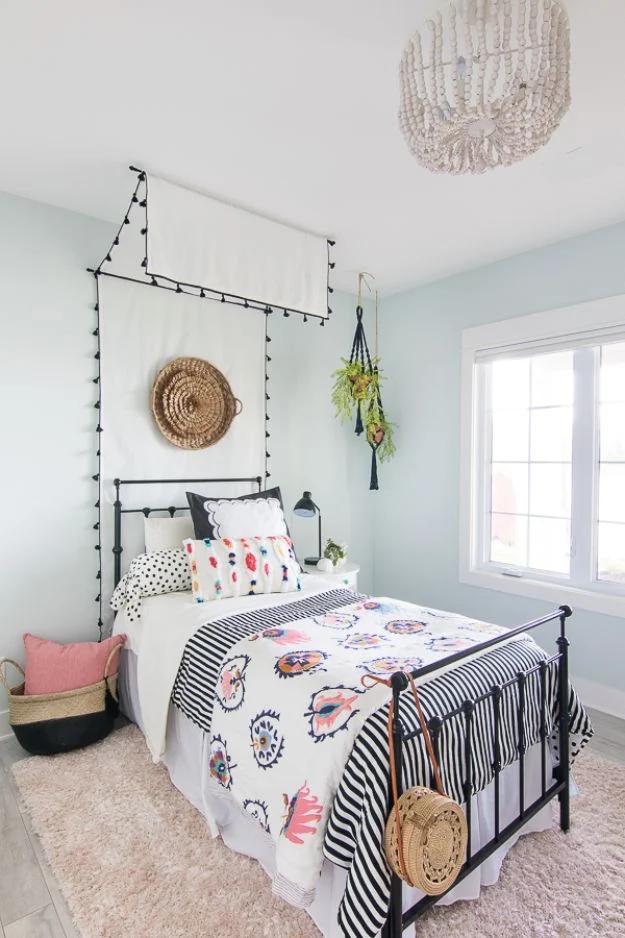 Tween beachy boho bedroom with a black metal bed, white canopy, woven basket and black and white bedding