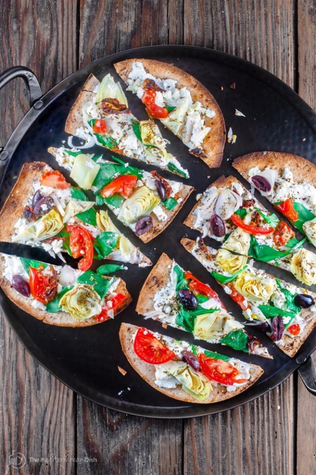 Artichoke garden flatbread pizza appetizer with ricotta, feta, marinated artichokes, spinach and kalamata olives