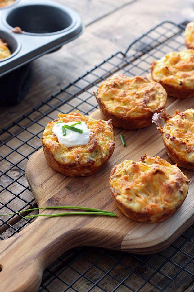 Golden baked mashed potato puffs cooling on a wire rack and wood board, one of them topped with sour cream