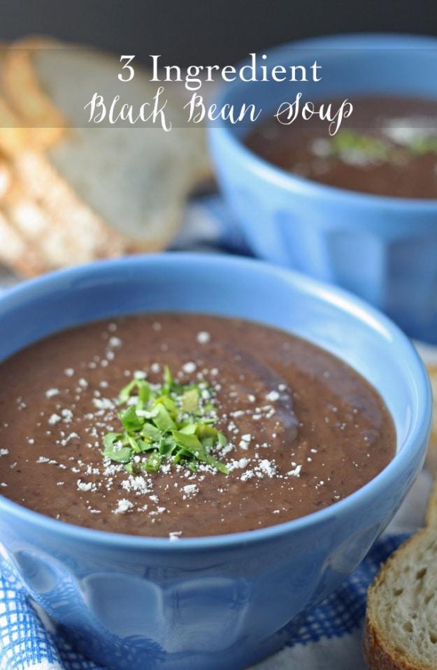 A blue bowl of thick black bean soup topped with chopped chives, an easy 3 ingredient pantry dinner recipe
