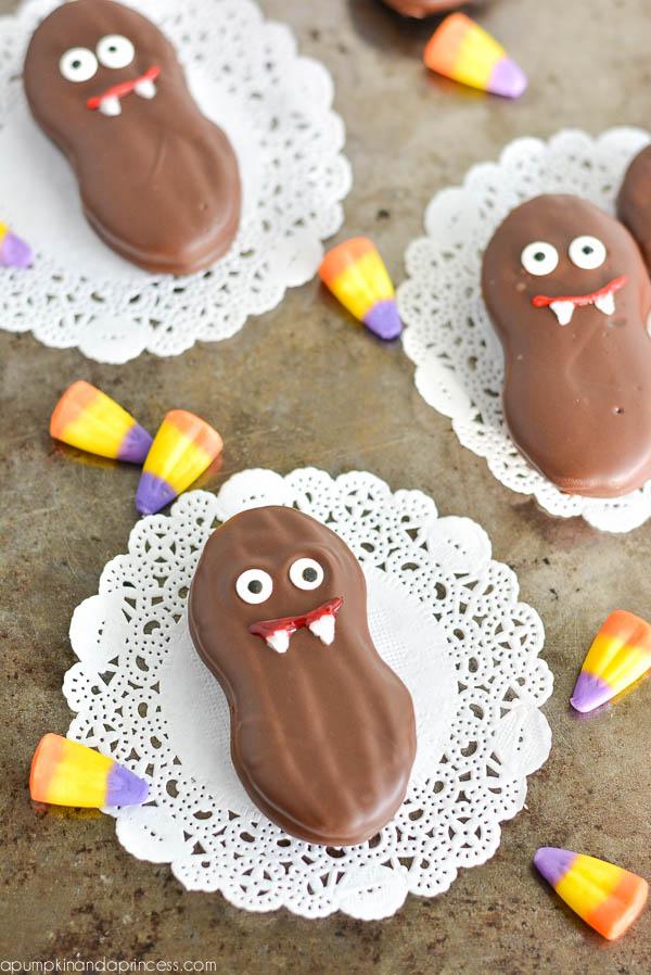 Chocolate-dipped Nutter Butter vampire cookies with candy eyes, red gel mouths and white teeth for Halloween