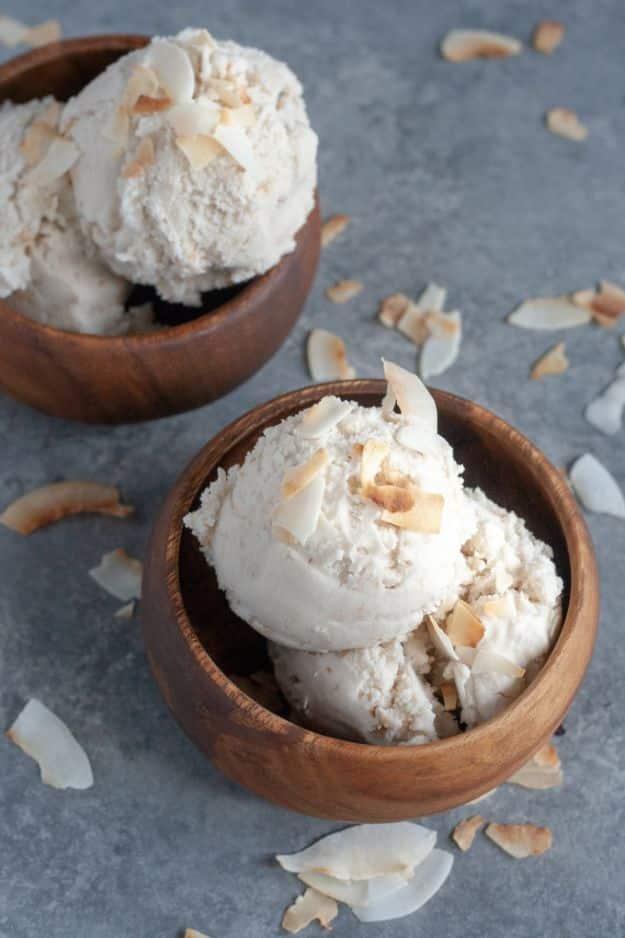 Toasted coconut ice cream in a dish topped with golden toasted coconut flakes, a vegan dairy free dessert