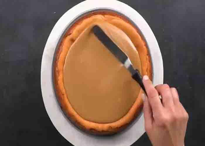 Adding the praline topping over the pumpkin pecan cheesecake