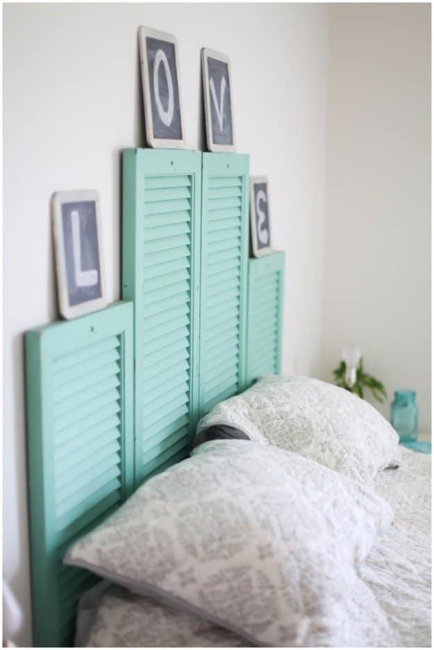 DIY vintage shutter headboard, four mint green louvered shutters hung at stepped heights with chalkboard letters
