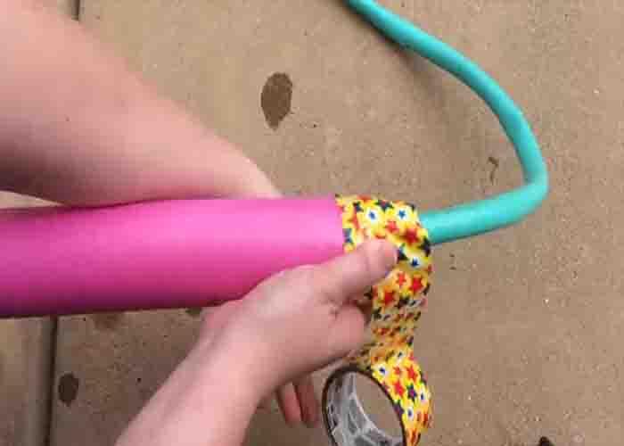 Securing the water hose to the pool noodle using duct tape