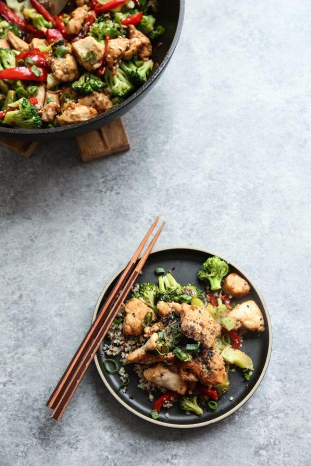 Healthy sesame chicken with broccoli on a dark plate with chopsticks, chicken pieces and broccoli florets