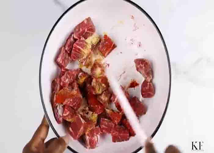 Seasoning the beef for the beef and potato stew