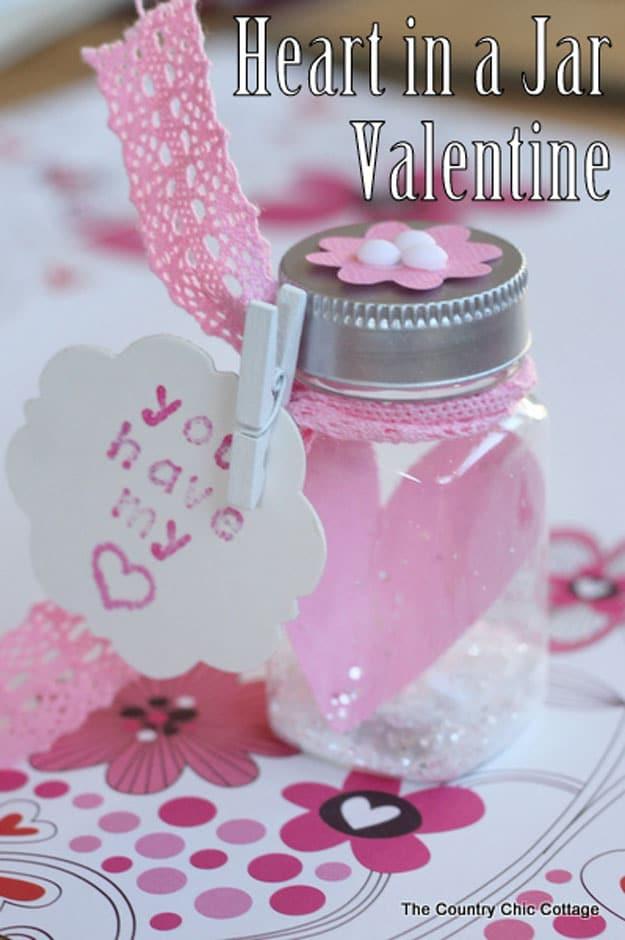 Single fabric heart suspended on a thread inside a clear glass jar as a minimal Valentine decoration