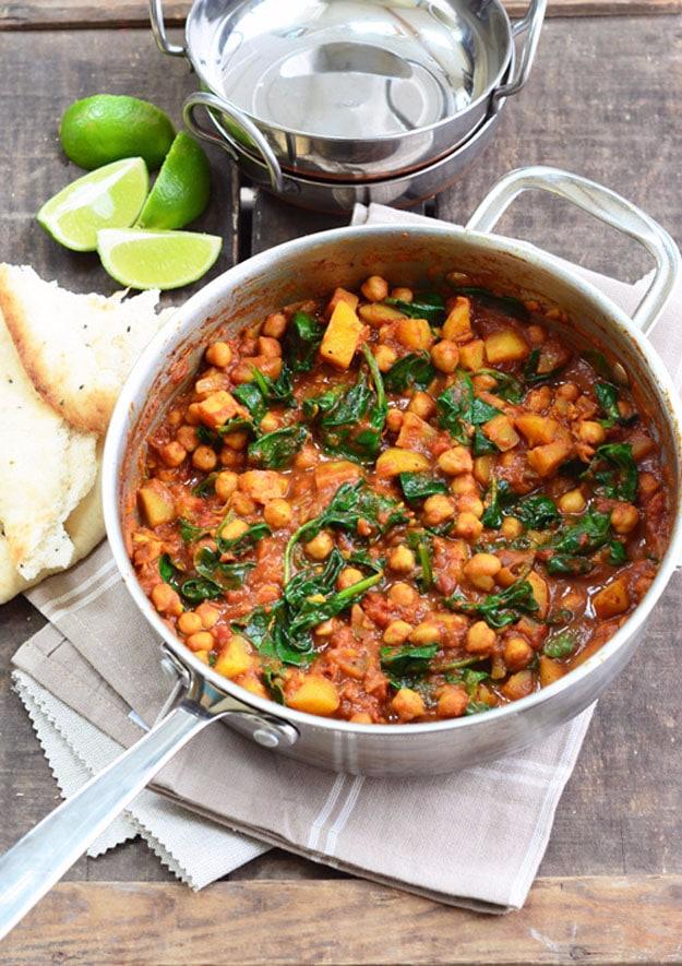 Chickpea and spinach curry with cubed potatoes in a spiced tomato and onion sauce in a deep pot for a vegan dinner
