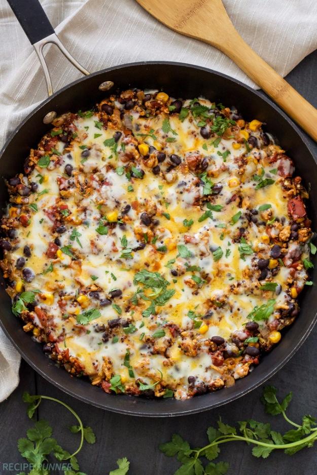 Turkey taco quinoa skillet with black beans, fire roasted corn and tomatoes under melted cheese ready to serve at home