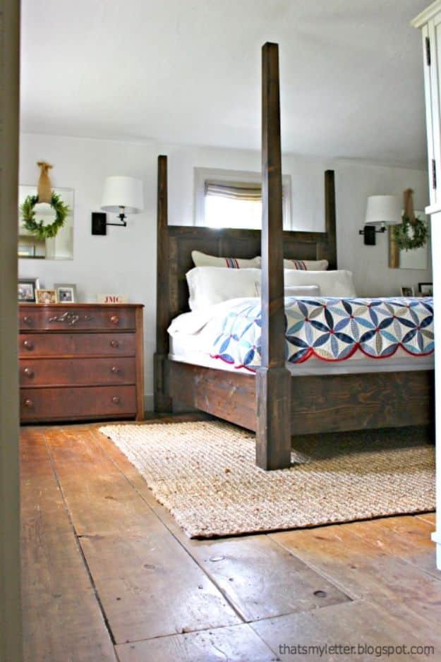DIY four poster bed frame in dark stained wood with tall posts and a paneled headboard covering a window