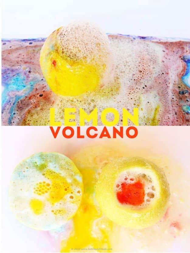 Halved and cored lemons erupting in colorful foam after baking soda is added, sitting on a white tray